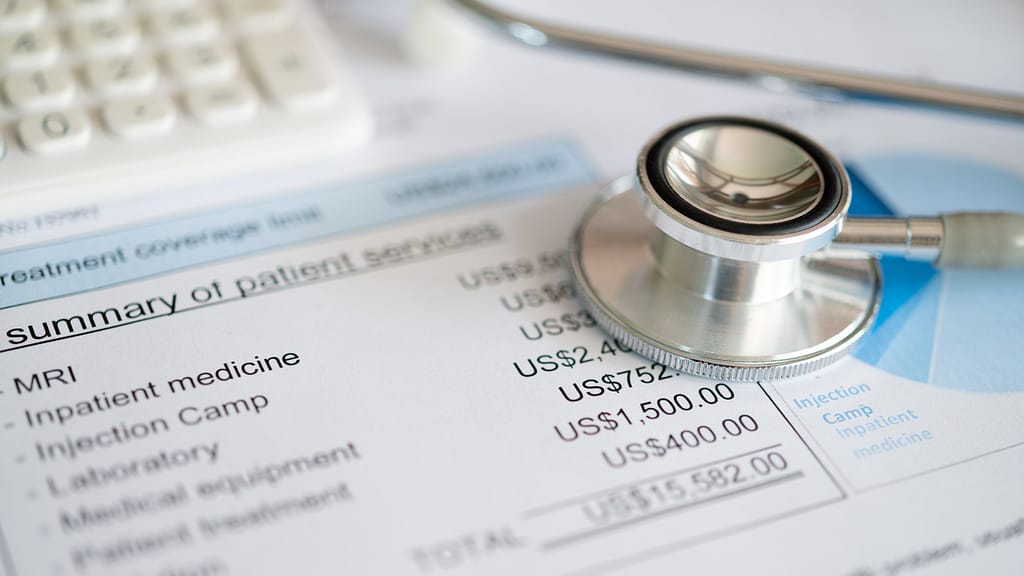 A stethoscope and calculator on top of a medical bill, emphasizing the importance of price transparency in health care.