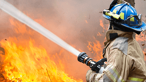 A firefighter putting out a wildfire, emphasizing the importance of enhanced wildfire response in Texas.