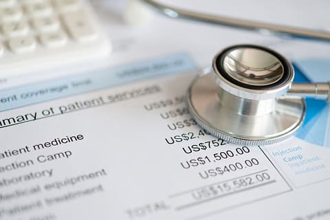 A stethoscope and calculator on top of a medical bill, emphasizing the importance of price transparency in health care.