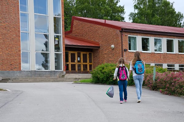 Students with backpacks walking into school