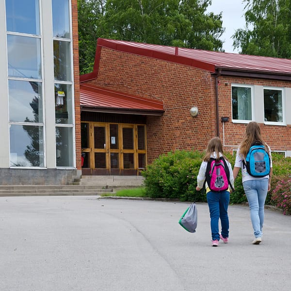 Students with backpacks walking into school
