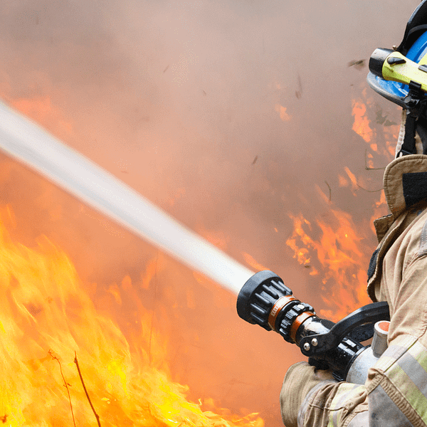 A firefighter putting out a wildfire, emphasizing the importance of enhanced wildfire response in Texas.